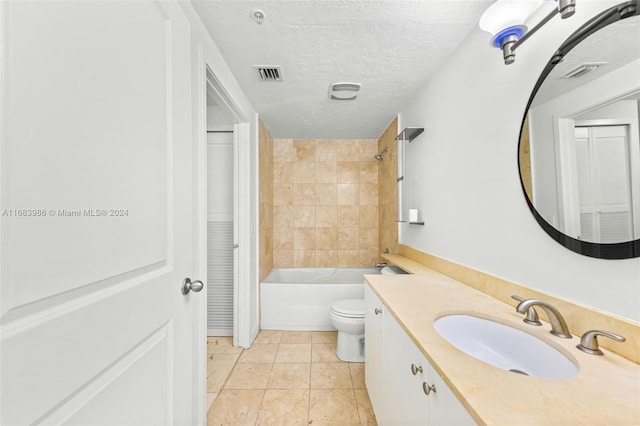 full bathroom with tile patterned floors, a textured ceiling, toilet, vanity, and tiled shower / bath