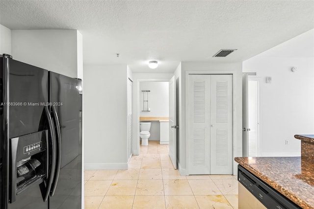 kitchen featuring stainless steel dishwasher, black fridge with ice dispenser, light tile patterned floors, and a textured ceiling