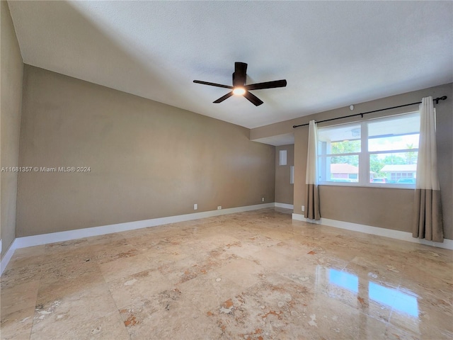 spare room featuring ceiling fan and a textured ceiling