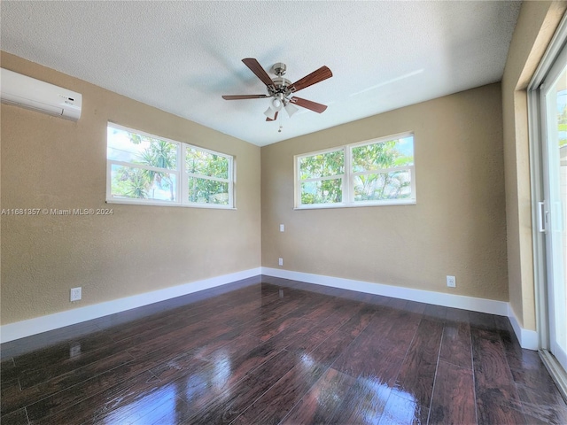 unfurnished room featuring a textured ceiling, a wall mounted AC, ceiling fan, and dark hardwood / wood-style flooring