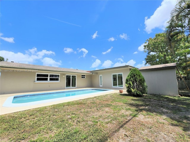 back of house featuring a patio area and a lawn