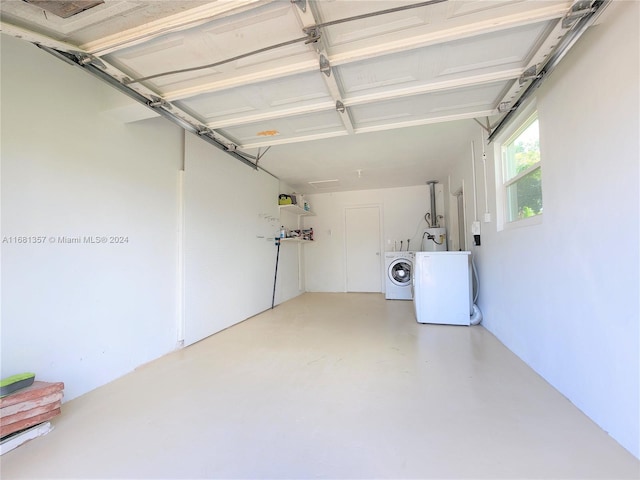 garage featuring secured water heater and washer and clothes dryer