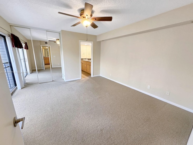 carpeted empty room with a textured ceiling and ceiling fan