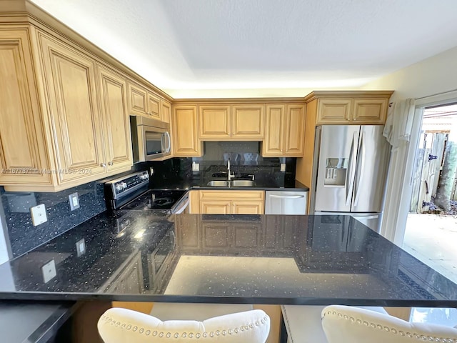 kitchen featuring backsplash, a breakfast bar, dark stone counters, sink, and stainless steel appliances