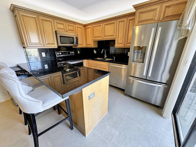 kitchen featuring a kitchen breakfast bar, dark stone countertops, light tile patterned floors, appliances with stainless steel finishes, and tasteful backsplash