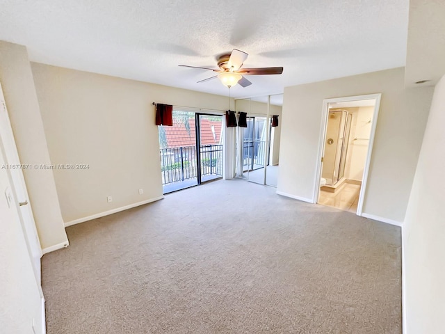 carpeted empty room featuring a textured ceiling and ceiling fan