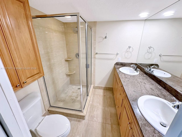 bathroom with a shower with door, vanity, toilet, and tile patterned floors