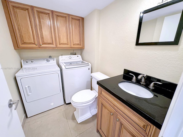 bathroom featuring toilet, washer and dryer, vanity, and tile patterned floors