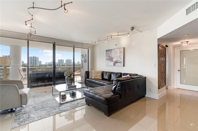 living room featuring rail lighting, light tile patterned floors, and plenty of natural light