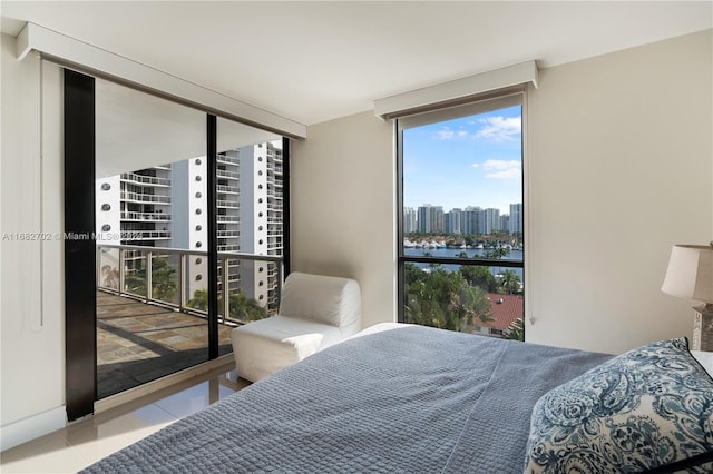 tiled bedroom featuring a wall of windows