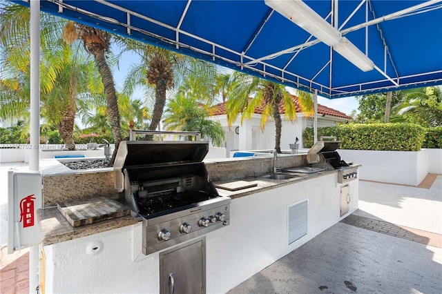 view of patio / terrace with an outdoor kitchen, sink, and grilling area