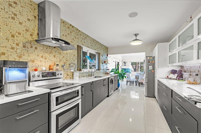 kitchen featuring decorative backsplash, wall chimney exhaust hood, sink, white cabinetry, and appliances with stainless steel finishes