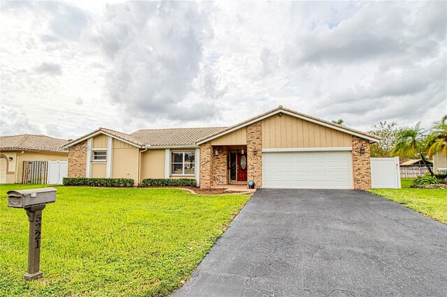 single story home featuring a front yard and a garage