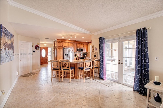 kitchen with backsplash, a kitchen bar, ornamental molding, stainless steel appliances, and french doors