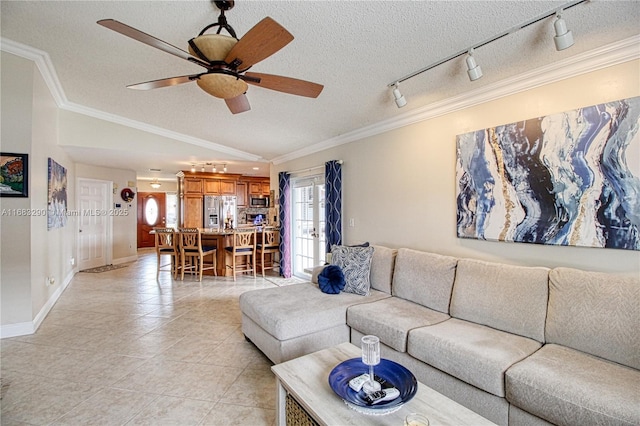 living room featuring light tile patterned floors, crown molding, a textured ceiling, and ceiling fan