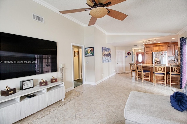 tiled living room featuring lofted ceiling, ceiling fan, ornamental molding, and a textured ceiling