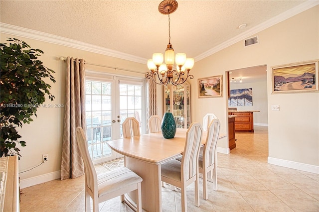 tiled dining area with vaulted ceiling, a chandelier, crown molding, a textured ceiling, and french doors