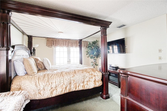 bedroom featuring light colored carpet and a textured ceiling