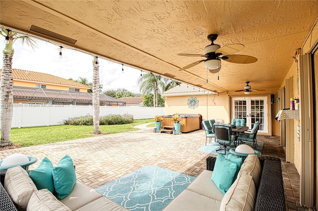 view of patio / terrace with a hot tub, outdoor lounge area, french doors, and ceiling fan