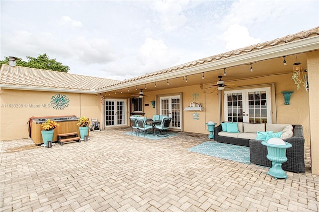 view of patio / terrace with a hot tub, an outdoor hangout area, ceiling fan, and french doors