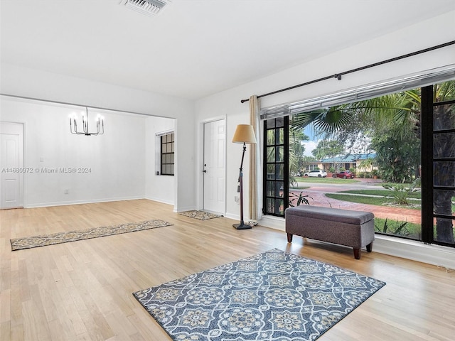 sitting room featuring a notable chandelier and wood-type flooring