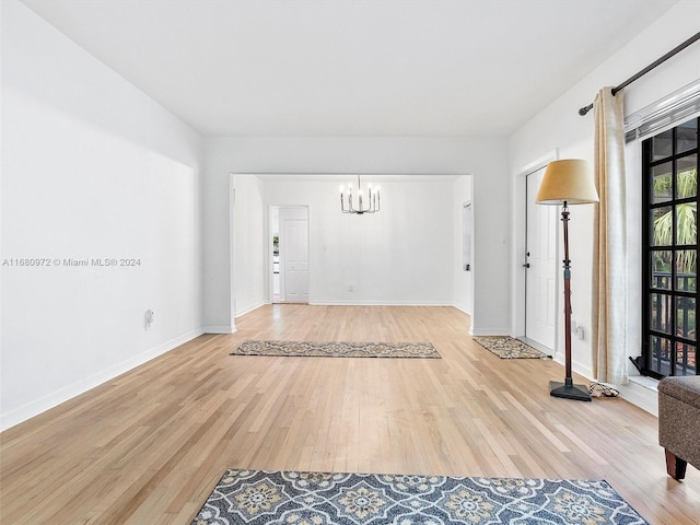 entrance foyer with hardwood / wood-style floors and an inviting chandelier