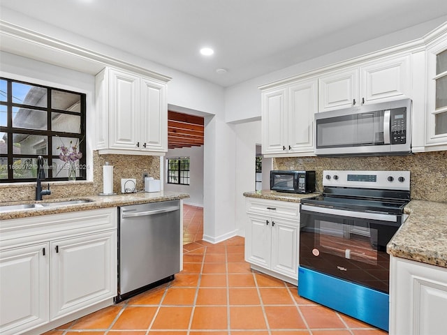 kitchen featuring tasteful backsplash, appliances with stainless steel finishes, sink, and white cabinets