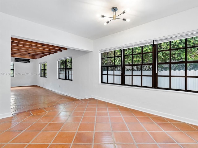 tiled empty room featuring beam ceiling, an inviting chandelier, and a wall unit AC