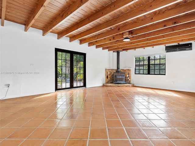 unfurnished living room with beam ceiling, a healthy amount of sunlight, an AC wall unit, and tile patterned floors