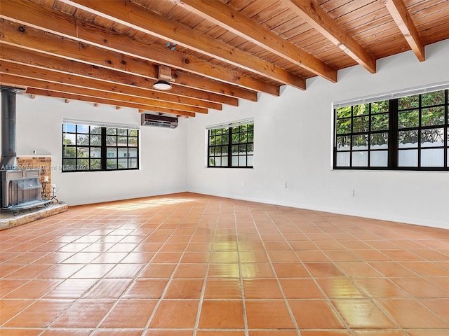 unfurnished living room featuring beam ceiling, tile patterned floors, a wall mounted air conditioner, and wooden ceiling