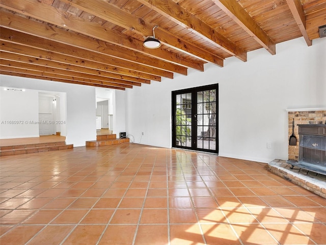 unfurnished living room with beamed ceiling, french doors, light tile patterned flooring, and wooden ceiling