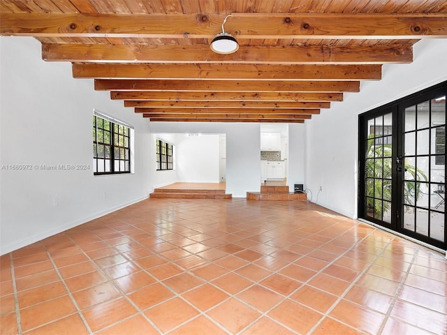 tiled spare room with wooden ceiling, beamed ceiling, plenty of natural light, and french doors