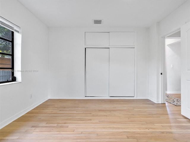 unfurnished bedroom featuring a closet and light hardwood / wood-style floors