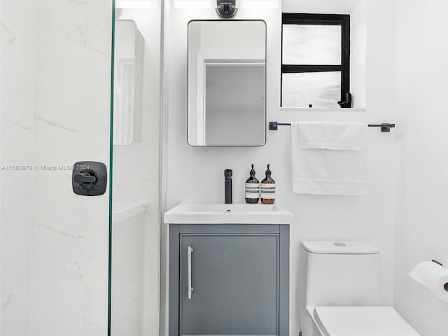 bathroom featuring vanity, a shower, and toilet