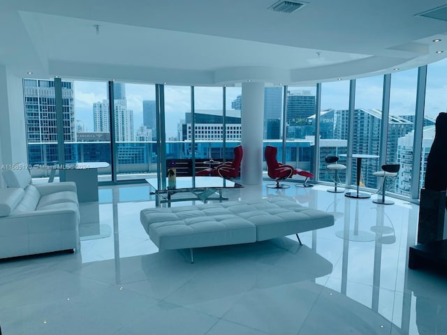 tiled living room featuring a wall of windows