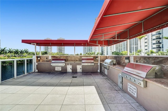 view of patio / terrace with area for grilling and a water view