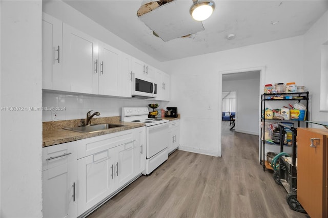 kitchen with sink, white cabinetry, light wood-type flooring, and white appliances