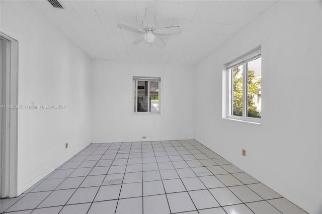 tiled spare room featuring ceiling fan