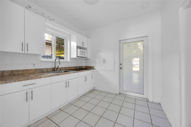 kitchen with white cabinets, tasteful backsplash, sink, and light tile patterned floors