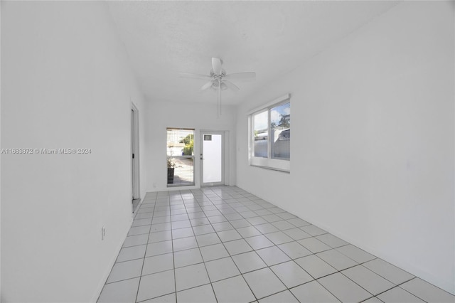 tiled spare room featuring ceiling fan