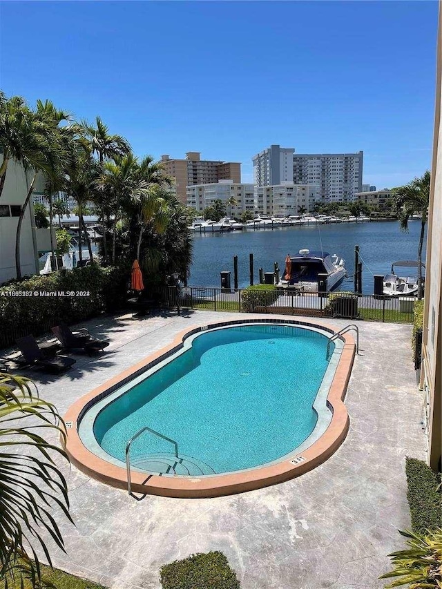 view of swimming pool with a patio and a water view