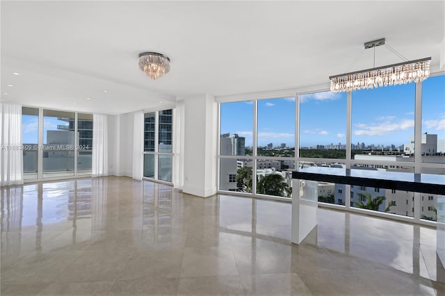 spare room featuring expansive windows and a chandelier