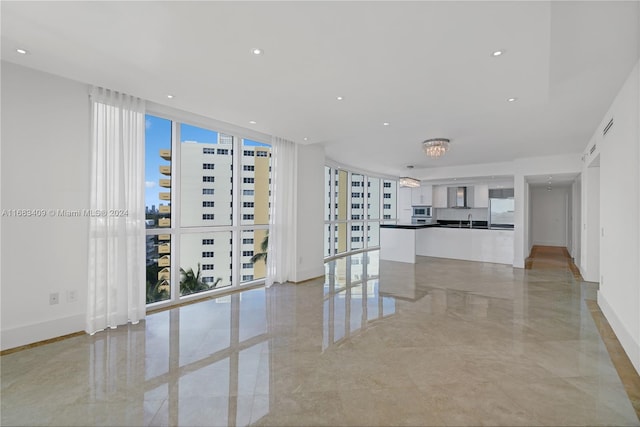 unfurnished living room with sink and floor to ceiling windows