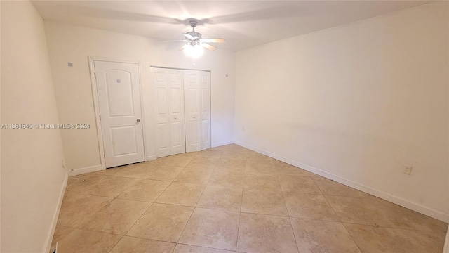 unfurnished bedroom with ceiling fan, a closet, and light tile patterned flooring