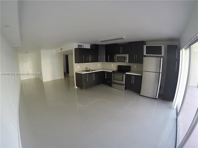 9367 Fontainebleau Blvd Unit G120, Miami, FL 33172 - kitchen featuring appliances with stainless steel finishes, dark cabinetry, a sink, light countertops, and light tile patterned floors