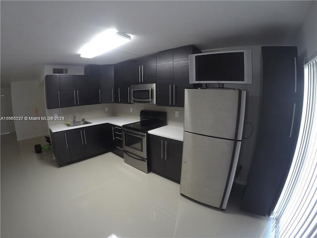 9367 Fontainebleau Blvd Unit G120, Miami, FL 33172 - kitchen featuring stainless steel appliances, dark cabinetry, a sink, and light countertops