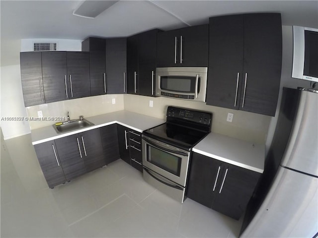 kitchen with light tile patterned floors, appliances with stainless steel finishes, and sink