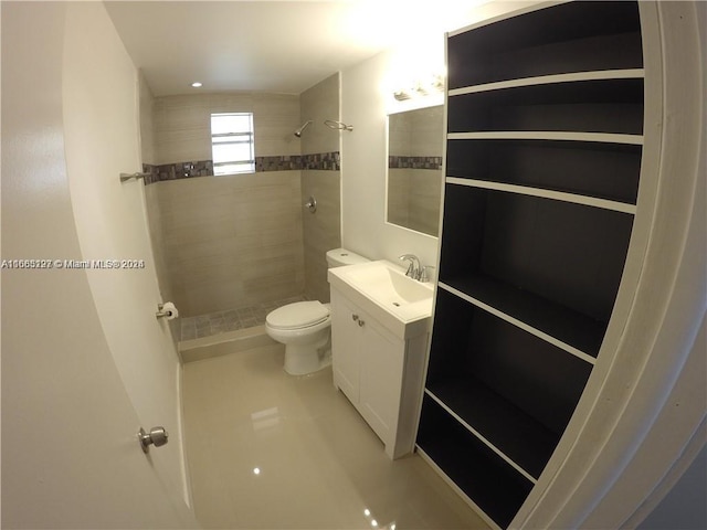 bathroom featuring vanity, toilet, and a tile shower