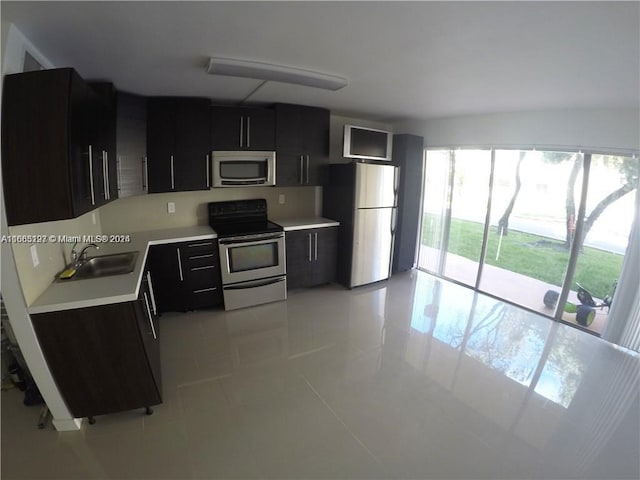 9367 Fontainebleau Blvd Unit G120, Miami, FL 33172 - kitchen featuring stainless steel appliances, dark cabinets, a sink, light countertops, and light tile patterned floors