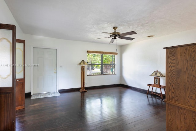 unfurnished room with a textured ceiling, dark wood-type flooring, and ceiling fan